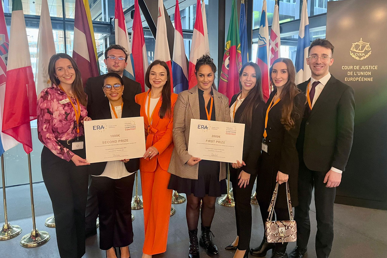 Winners of the Young European Lawyers Contest holding their prize certificates at the Court of Justice of the European Union, celebrating excellence and cooperation in European law.