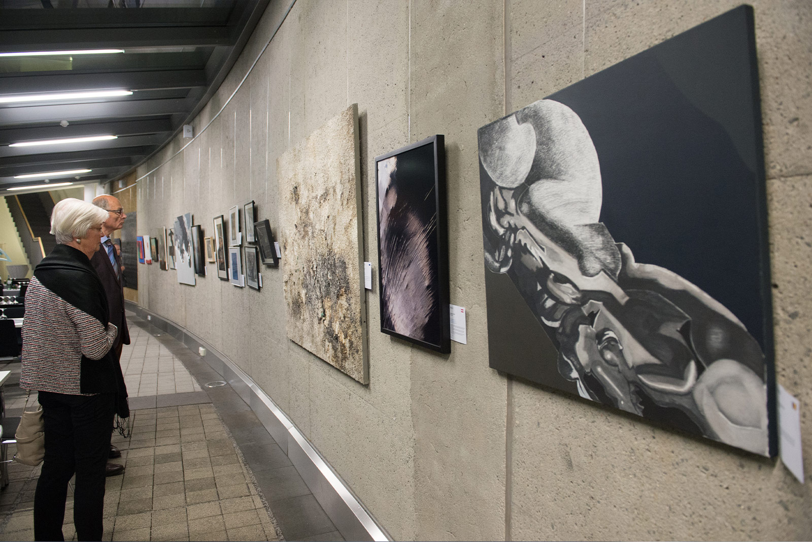 Visitors viewing artworks displayed along the curved gallery wall at the ERA building, part of the ERA Jubilee Fund initiative “Art Knows no Frontiers” celebrating creativity and European cultural exchange.