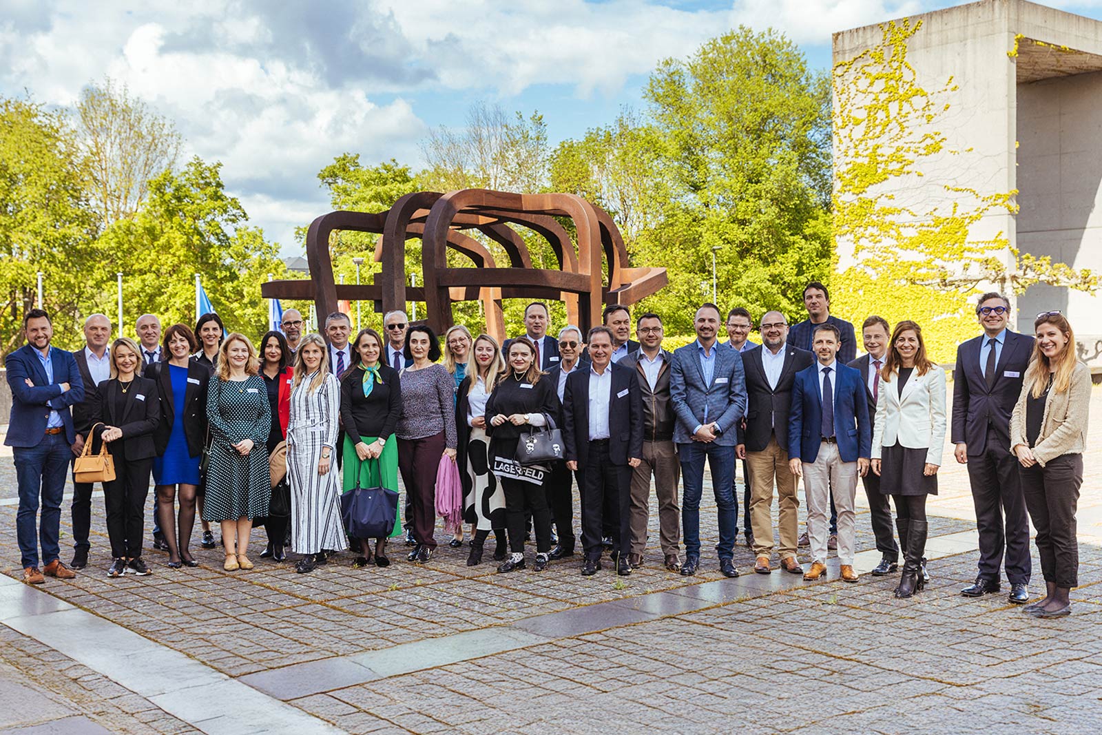 Group photo of Friends of ERA members and participants standing outside the ERA building in Trier, representing European cooperation, learning, and professional exchange.