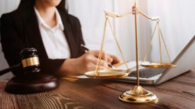Woman sitting on a desk with a scale on top of it